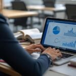 Woman working on laptop with charts and graphs.