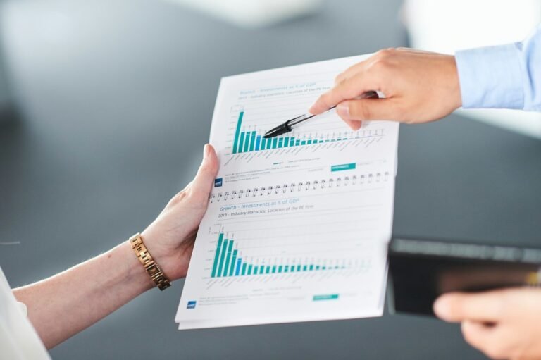 Two people analyzing a document with green bar charts